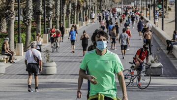 Un hombre con mascarilla en la playa de la Malvarrosa en Valencia