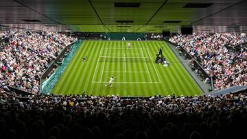 Serbia's Novak Djokovic (front) returns the ball to Argentina's Pedro Cachin during their men's singles tennis match on the first day of the 2023 Wimbledon Championships at The All England Tennis Club in Wimbledon, southwest London, on July 3, 2023. (Photo by Daniel LEAL / AFP) / RESTRICTED TO EDITORIAL USE