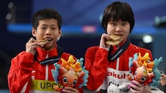 China's gold-medallists Huang Jianjie and Zhang Jiaqi pose for a picture with their medals after the final of the mixed 10m platform synchro diving event during the 2024 World Aquatics Championships at Hamad Aquatics Centre in Doha on February 3, 2024. (Photo by SEBASTIEN BOZON / AFP)
