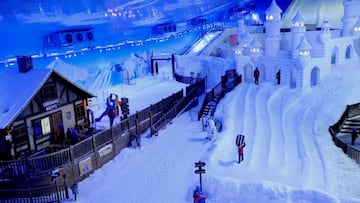 Zona de bar con chocolate caliente, un castilo de nieve, una pista de esqu&iacute; y varias personas usando las instalaciones de Snowland Gramado (Brasil).