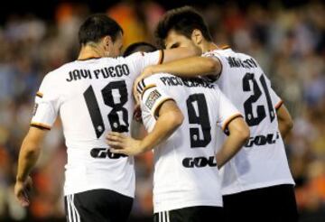 Los jugadores del Valencia Javi Fuego (i), Paco Alcácer (c) y el portugués André Gomes celebran uno de sus goles durante el encuentro correspondiente a la novena jornada de primera división, que disputan esta noche en el estadio de Mestalla.