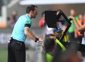 Referee Marco Fritz checks the Video assistant referee (VAR) during the German first division Bundesliga football match between FC Augsburg and Borussia Dortmund.