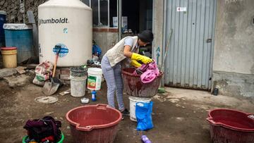 A woman washes clothes outside her house at the Pamplona Alta section in the southern outskirts of Lima on May 28, 2020, amid water shortage during the new coronavirus pandemic. (Photo by ERNESTO BENAVIDES / AFP)