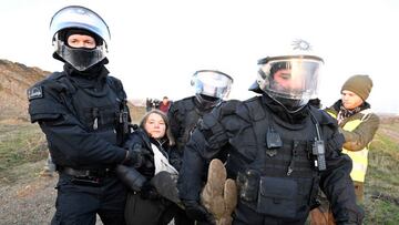 17 January 2023, North Rhine-Westphalia, Erkelenz: Police officers carry Swedish climate activist Greta Thunberg (M) out of a group of protesters and activists and away from the edge of the Garzweiler II opencast lignite mine. Activists and coal opponents continue their protests at several locations in North Rhine-Westphalia on Tuesday. Photo: Roberto Pfeil/dpa (Photo by Roberto Pfeil/picture alliance via Getty Images)