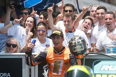 El piloto de 19 años celebra con su equipo, el RedBull KTM Ajo, el triunfo que supuso el campeonato del mundo de Moto3.
