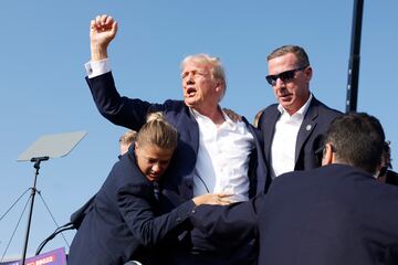 El expresidente, Donal Trump, es evacuado por el servicio secreto del estrado, con algo de sangre  en el rostro, tras escucharse disparos. El candidato republicano ha salido por su propio pie con el puño en alto.