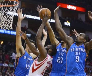 Steven Adams (I) Andre Roberson (C-D) y Serge Ibaka (D) tratan de taponar el tiro de James Harden (C-I).