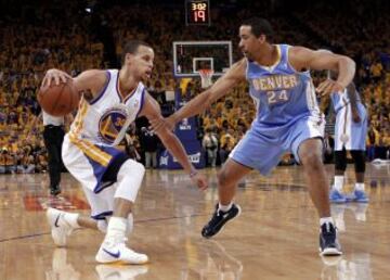 Stephen Curry de los warriors controla el balón frente a Andre Miller de Denver Nuggets en el cuarto partido de las eliminatorias de baloncesto de la División Oeste.