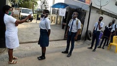 A health worker checks the temperature with an infrared thermometer of students queueing and keeping distances on resumption of studies at Access International Schools, in Magboro, Ogun State, southwest Nigeria, on August 4, 2020. - Secondary schools acro