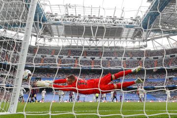 Real Madrid's goalkeeper, Andriy Lunin, stops the ball during the match of the ninth round of the League that Real Madrid and FC Barcelona played at the Santiago Bernabéu stadium.
