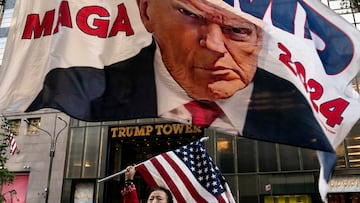 A supporter of former U.S. President Donald Trump holds up a U.S. national flag at Trump Tower in New York City, U.S., October 1, 2023. REUTERS/David 'Dee' Delgado     TPX IMAGES OF THE DAY