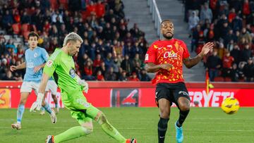 PALMA, 13/01/2024.- El delantero canadiense del Mallorca Cyle Larin (d) intenta superar al portero del Celta Vicente Guaita durante el partido de LaLiga entre el Mallorca y el Celta que se disputa este sábado en el estadio de Son Moix. EFE/CATI CLADERA
