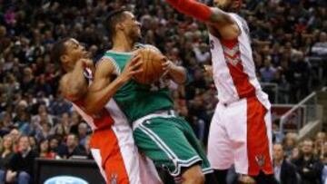 James Johnson y guard Kyle Lowry tratan de parar a Evan Turner.
