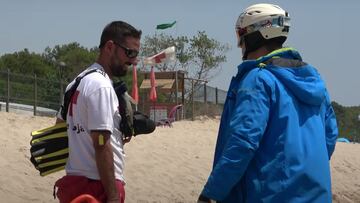 Un socorrista de Cruz Roja se mira al youtuber D&iacute;dac Ribot, vestido de esqu&iacute;, en la playa. 