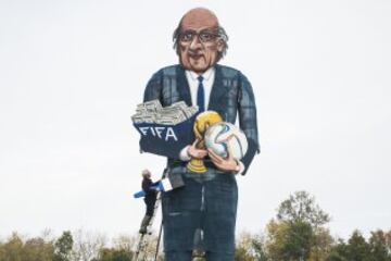 El artista británico, Frank Shepherd, posa tras finalizar un cartel gigante del presidente suspendido de la FIFA, Joseph Blatter. 