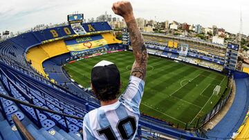 Un hincha con la camiseta de Argentina posa frente a una gran pancarta de homenaje a Maradona, en una panorámica de La Bombonera completamente vacía, antes del partido entre Boca Juniors y Newells Old Boys. Tras la muerte de la leyenda, el campeonato argentino ha sido rebautizado con el nombre Copa Diego Armando Maradona.