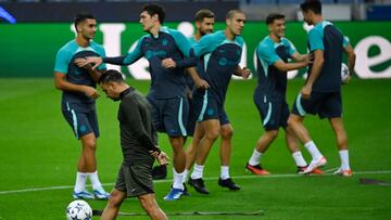 Xavi controla el balón mientras los jugadores hacen ejercicios sobre el césped del estadio portugués.
