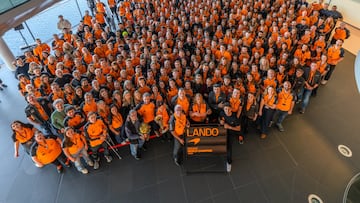Los trabajadores de McLaren posan junto a Norris y los títulos de F1 en Woking.