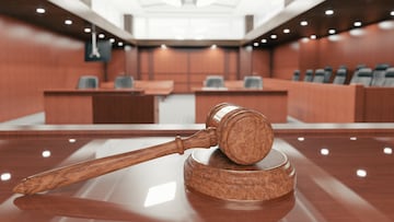 Interior of an empty courtroom with gavel and sounding block on the desk. SENTENCIA JUDIAL LEY JUICIO JUSTICIA