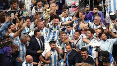 LUSAIL CITY, QATAR - DECEMBER 18: Lionel Messi of Argentina celebrates with the FIFA World Cup Qatar 2022 Winner's Trophy on the shoulders of former teammate Sergio Aguero after the team's victory during the FIFA World Cup Qatar 2022 Final match between Argentina and France at Lusail Stadium on December 18, 2022 in Lusail City, Qatar. (Photo by Alex Pantling/Getty Images)
