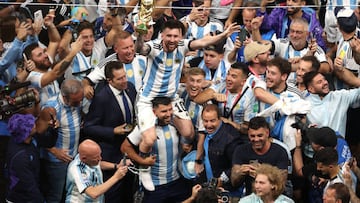 LUSAIL CITY, QATAR - DECEMBER 18: Lionel Messi of Argentina celebrates with the FIFA World Cup Qatar 2022 Winner's Trophy on the shoulders of former teammate Sergio Aguero after the team's victory during the FIFA World Cup Qatar 2022 Final match between Argentina and France at Lusail Stadium on December 18, 2022 in Lusail City, Qatar. (Photo by Alex Pantling/Getty Images)