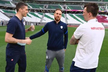 Oblak conversa antes del partido con Mandzukic, actualmente parte del cuerpo técnico de Croacia.