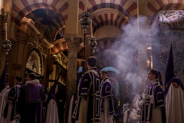 Penitentes de la hermandad de la Agonía participan en una procesión de Semana Santa en la Mezquita-Catedral de Córdoba, Andalucía.