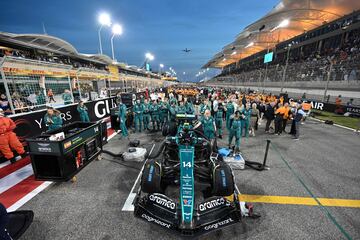 Los miembros del equipo de Aston Martin junto al coche del piloto español Fernando Alonso antes del inicio del Gran Premio. 