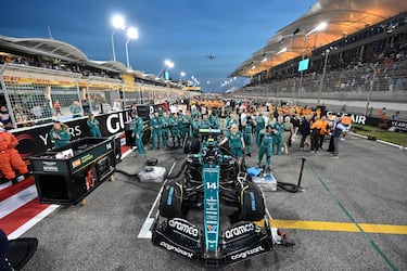Los miembros del equipo de Aston Martin junto al coche del piloto español Fernando Alonso antes del inicio del Gran Premio. 