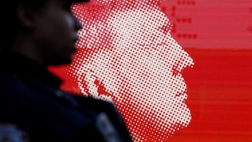 FILE PHOTO: A NYPD officer stands in front of an image of Republican presidential nominee and former U.S. President Donald Trump outside Madison Square Garden on the day of Trump's rally, in New York, U.S., October 27, 2024. REUTERS/David Dee Delgado/File Photo