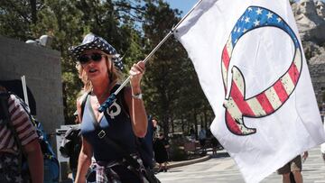 (ARCHIVOS) En esta foto de archivo tomada el 1 de julio de 2020, un partidario de Donald Trump con una bandera de QAnon visita el Monumento Nacional Mount Rushmore en Keystone, Dakota del Sur.