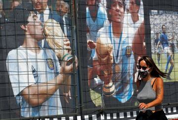 A woman walks past a billboard in homage to Argentinian soccer legend Diego Armando Maradona on his 60th birthday, near the Buenos Aires' Obelisk, in Argentina October 30, 2020. REUTERS/Agustin Marcarian
