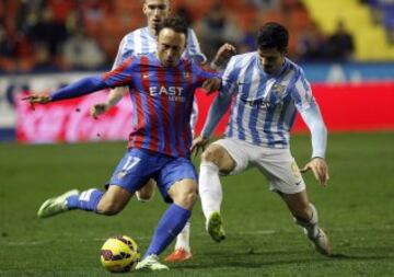 El centrocampista del Levante Jordi Xumetra disputa el balón con el delantero del Málaga Javi Guerra.