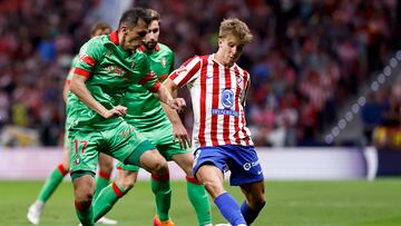 Budimir disputa un balón con Barrios.