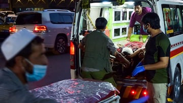 EDITORS NOTE: Graphic content / Medical staff bring an injured man to a hospital in an ambulance after two powerful explosions, which killed at least six people, outside the airport in Kabul on August 26, 2021. (Photo by Wakil KOHSAR / AFP)