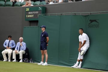 Nick Kyrgios rests during a break in play against Pierre-Hughes Herbert.