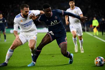 Real Madrid's Spanish defender Dani Carvajal (L) and Paris Saint-Germain's Portuguese defender Nuno Mendes (R) fight for the ball during the UEFA Champions League round of 16 first leg football match between Paris Saint-Germain (PSG) and Real Madrid at the Parc des Princes stadium in Paris on February 15, 2022. (Photo by FRANCK FIFE / AFP)