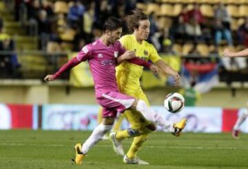 El centrocampista del Villarreal Pina (d) pelea un balón con López, del Cádiz, durante el partido de vuelta de los dieciseisavos de final de la Copa del Rey que disputan esta noche en el estadio de El Madrigal, en Villarreal. 