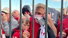Liverpool fans react as they queue to access Stade de France before the Champions League Final.