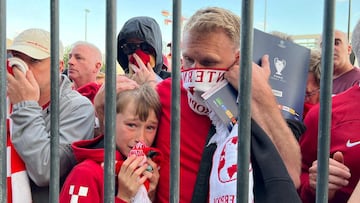 Liverpool fans react as they queue to access Stade de France before the Champions League Final.