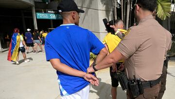 Police officers arrest a Colombia's supporter that tried to get into the stadium without tickets ahead of the Conmebol 2024 Copa America tournament final football match between Argentina and Colombia at the Hard Rock Stadium, in Miami, Florida on July 14, 2024. (Photo by JUAN MABROMATA / AFP)