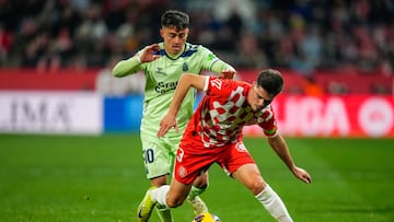 GIRONA, 03/02/2025.- El lateral del Girona Miguel Gutiérrez (d) protege un balón ante Alberto Moleiro, de Las Palmas, durante el partido de LaLiga EA Sports que Girona FC y UD Las Palmas disputan este lunes en el estadio de Montilivi. EFE/Siu Wu