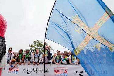  El presidente del principado de Asturias, Adrián Barbón, ondea una bandera gigante de Asturias en el desfile folclórico antes del comienzo de la prueba del Descenso Internacional del Sella de piragüismo en Arriondas.