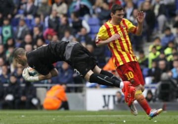 El portero del Espanyol Kiko Casilla (i) atrapa el balón ante el delantero argentino del Barcelona Leo Messi en el partido de la trigésima primera jornada de liga en Primera División que se disputa esta tarde en el estadio Cornellá-El Prat.
