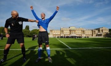 Partido entre los clubes de aficionados Polytechnic FC (azul) y el Civil Service FC en los jardines del Buckingham Palace. El árbitro Howard Webb bromea con el jugador del Polytechnic FC Bojan Jelovac.