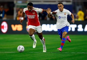 Jurrien Timber #12 of Arsenal controls the ball against Sergino Dest #2 of FC Barcelona.