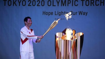 Japanese aerobatics pilot Hoshihide Muroya lights the celebration cauldron at Hibarigahara Festival Site, during the last leg of the first day of the Tokyo 2020 Olympic torch relay in Minamisoma, Fukushima Prefecture on March 25, 2021. (Photo by CHARLY TR