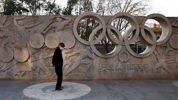 A man stands in front of a base relief containing the Olympic Rings in a park in Beijing as the city prepares for the 2022 Olympics, in Beijing, China, December 7, 2021. REUTERS/Thomas Peter