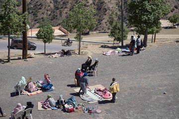 Las personas afectadas por el terremoto se sientan cerca de una carretera después de que sus casas resultaron dañadas, en la aldea de Moulay Brahim, cerca del epicentro del terremoto, en las afueras de Marrakech, Marruecos.