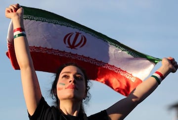 A woman holds up Iran's national flag as she watches a FIFA World Cup 2018 preliminary soccer match in the FIFA fan zone in Moscow